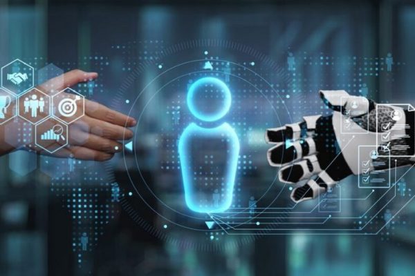 This image captures a symbolic interaction between a human hand and a robotic hand, representing the collaboration between humanity and technology in modern business environments. Auvana